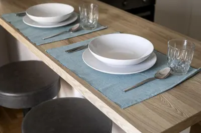 a wooden table with white plates and silverware on it at Attica - Captivating 2-Bedroom Apt & Balcony in Athens in Athens