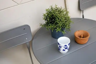 a table with a plant and a cup on it at Attica - Captivating 2-Bedroom Apt & Balcony in Athens in Athens