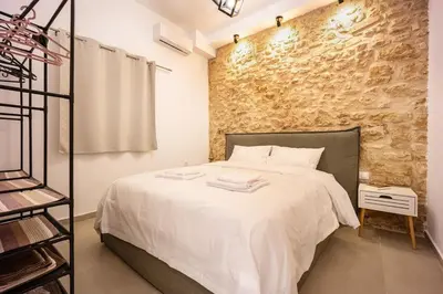 a bedroom with a bed and a brick wall at Kastella Luxe Stone in Piraeus