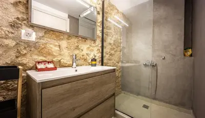 a bathroom with a sink and a shower at Kastella Luxe Stone in Piraeus