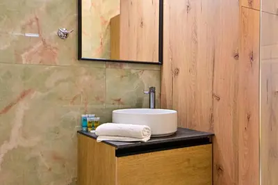 a bathroom with a sink on a wooden cabinet at Acropolis Luxurious Apartment 100 Mbps Metro Garden in Athens