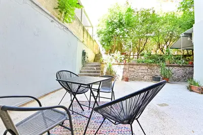 a table and chairs sitting on a patio at Acropolis Luxurious Apartment 100 Mbps Metro Garden in Athens