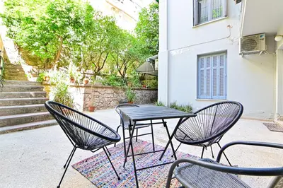 a group of chairs and a table in front of a building at Acropolis Luxurious Apartment 100 Mbps Metro Garden in Athens