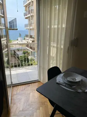 a dining room table with a view of a balcony at Athens Riviera Seaview in Athens