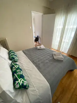 a large bed with green and white pillows on it at Athens Riviera Seaview in Athens
