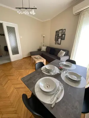 a living room with a table and a couch at Athens Riviera Seaview in Athens