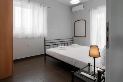 a bedroom with a bed and a mirror and a lamp at Villa PAPADATES NEFELI in Barbaliáki