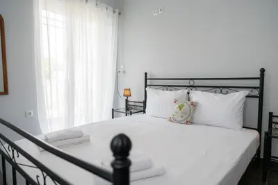 a bedroom with a black and white bed with white pillows at Villa PAPADATES NEFELI in Barbaliáki
