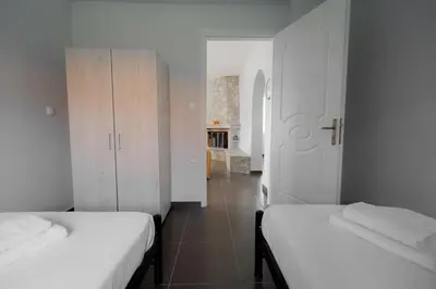 two beds in a small room with a hallway at Villa PAPADATES NEFELI in Barbaliáki