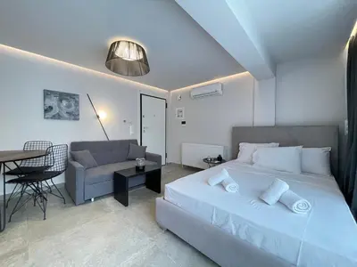 a bedroom with a bed and a couch and a table at Athenean Cozy Nest in Athens