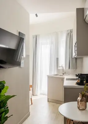 a white kitchen with a table and a window at Sol by Zoia Living in Athens