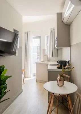 a white kitchen with a table and a table at Sol by Zoia Living in Athens