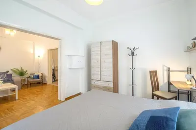 a bedroom with a bed and a living room at Spacious Sunny Apartment in Athens
