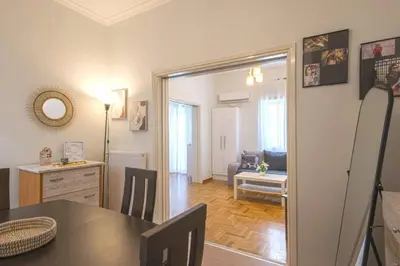 a kitchen and living room with a table and a dining room at Spacious Sunny Apartment in Athens