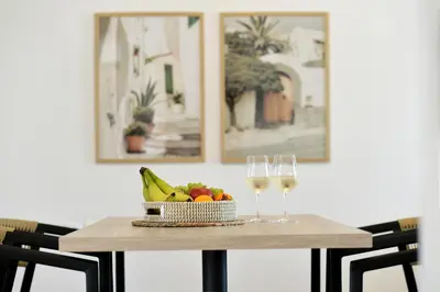 a table with a bowl of fruit and two glasses of wine at Athinais Park Acropolis View in Athens