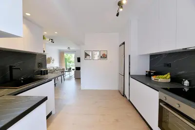 a kitchen with white counters and black counter tops at Athinais Park Acropolis View in Athens