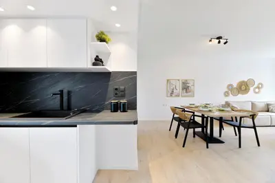 a kitchen and dining room with white cabinets and a table at Athinais Park Acropolis View in Athens