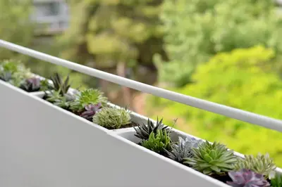 a row of potted plants on a white railing at Athinais Park Acropolis View in Athens