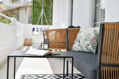 a table with an open book on it next to a couch at Athinais Park Acropolis View in Athens