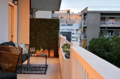 a balcony with a table and chairs on a building at Athinais Park Acropolis View in Athens