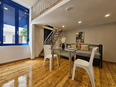 a bedroom with a bed and a table and chairs at Agia Sofia Cycladic Suites in Piraeus