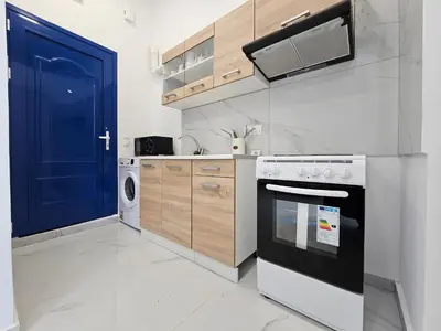 a kitchen with a stove and a blue door at Agia Sofia Cycladic Suites in Piraeus
