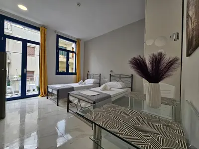 a living room with two beds and a table at Agia Sofia Cycladic Suites in Piraeus