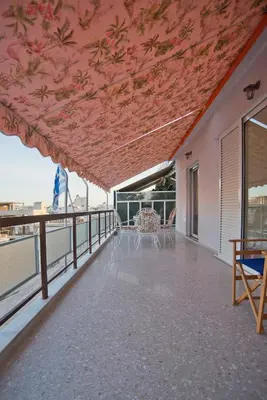 a balcony with a pink ceiling with tables and chairs at Kary's Acropolis View Luxury 2BR, 2 BA, Jacuzzi in Athens