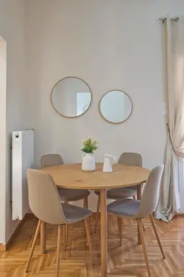 a dining room table with chairs and two mirrors at Kary's Acropolis View Luxury 2BR, 2 BA, Jacuzzi in Athens