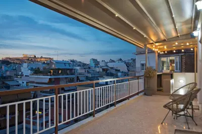 a balcony with a view of a city at night at Kary's Acropolis View Luxury 2BR, 2 BA, Jacuzzi in Athens