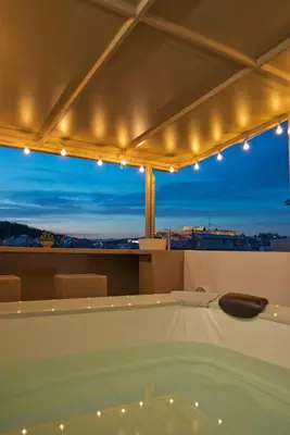 a bath tub with a view of a city at night at Kary's Acropolis View Luxury 2BR, 2 BA, Jacuzzi in Athens
