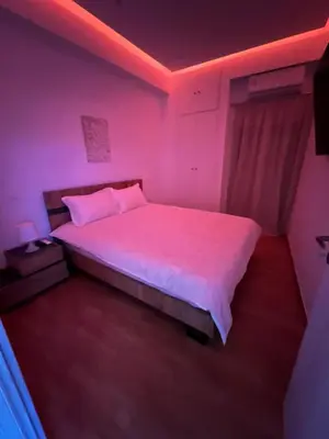 a bedroom with a bed with pink lights on it at Zea Sea View Apartment in Piraeus