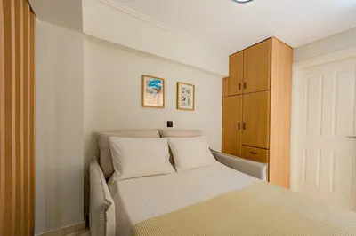 a small bedroom with a bed and a cabinet at Atherial Studio in Athens