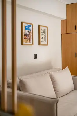 a white couch in a room with two pictures on the wall at Atherial Studio in Athens