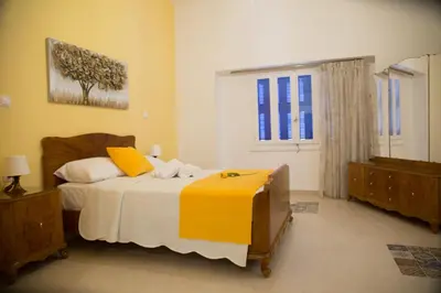a bedroom with a large bed and a window at Aimou Suites in Piraeus