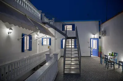 a staircase leading up to a building with a table at Aimou Suites in Piraeus