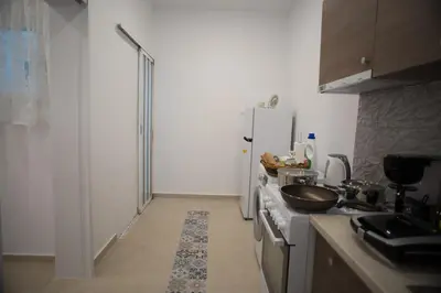 a kitchen with a white refrigerator and a sink at Aimou Suites in Piraeus