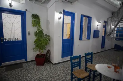 a room with blue doors and a table and chairs at Aimou Suites in Piraeus