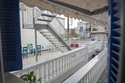 a staircase on a balcony with chairs and tables at Aimou Suites in Piraeus