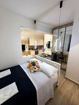 a bedroom with a large bed and a living room at Petit and Peaceful Retreat in Athens