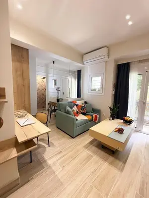 a living room with a couch and a table at Petit and Peaceful Retreat in Athens