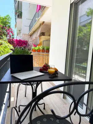 a laptop computer sitting on a table on a balcony at Petit and Peaceful Retreat in Athens