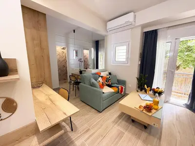 a living room with a couch and a table at Petit and Peaceful Retreat in Athens