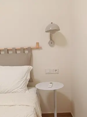 a bed and a table with a lamp next to a bed at Luxury Residency II Filolaou Blue in Athens