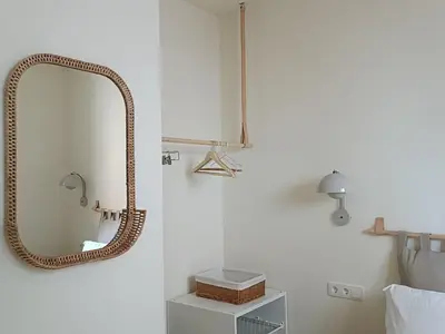 a bathroom with a rattan mirror on the wall at Luxury Residency II Filolaou Blue in Athens