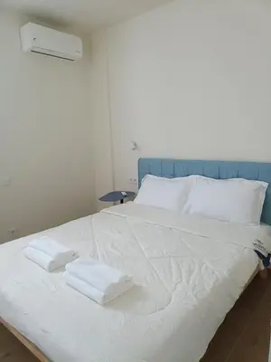 a large white bed with two towels on it at Luxury Residency II Filolaou Blue in Athens