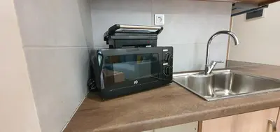 a microwave sitting on a kitchen counter next to a sink at A few minutes from Siggrou Street in Athens