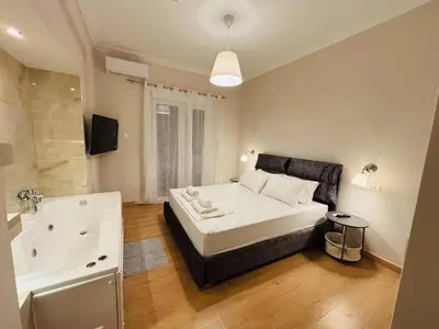 a bedroom with a large bed and a bath tub at Elysian Αpartment II in Athens