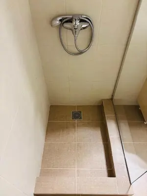 a shower in a room with a tile floor at Elysian Αpartment II in Athens