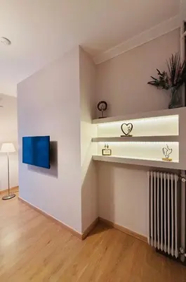 a living room with a radiator and a tv on a wall at Elysian Αpartment II in Athens